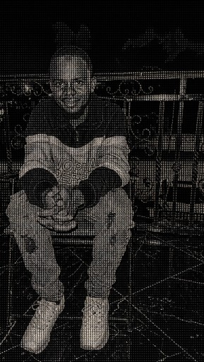 Monochrome ASCII-style portrait of a seated person on a balcony.