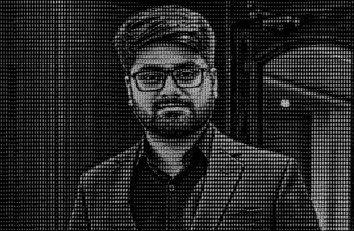 Monochrome ASCII portrait of a person wearing glasses and a suit.